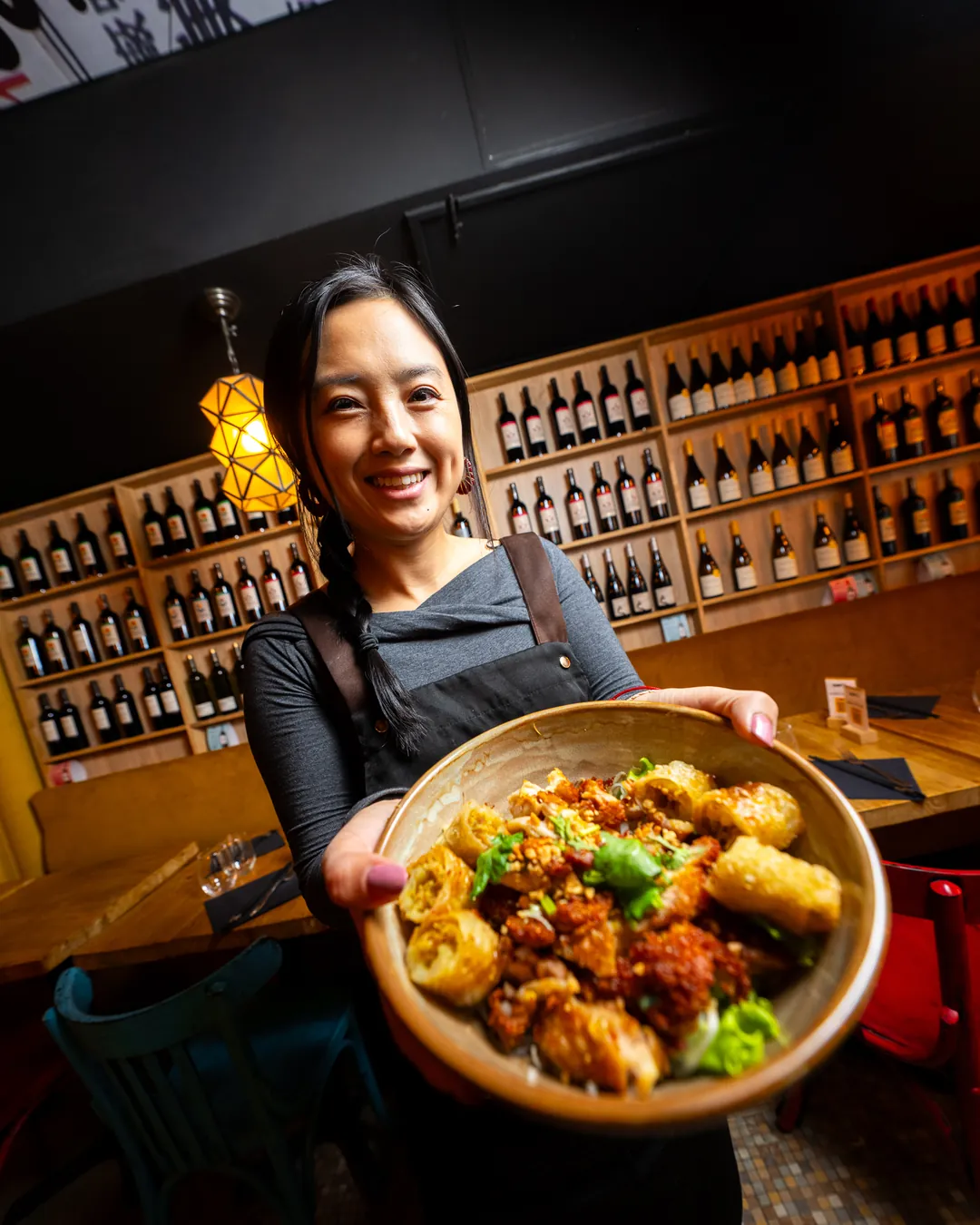 Une serveuse Mian Fan présente un plat devant le bar